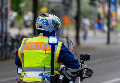 Rear view of police officer on motorbike, Berlin Germany Potsdamer Platz
