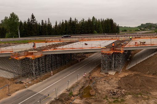 Drone photography of highway bridge being built during spring day. High angle view