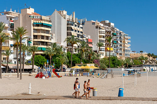 benidorm spain  july  28 - 2023 - four unknown people go to the beach poniente in benidorm to swim and sunbathe