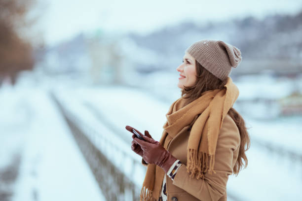 istock smiling elegant woman sending text message using smartphone 1633782697