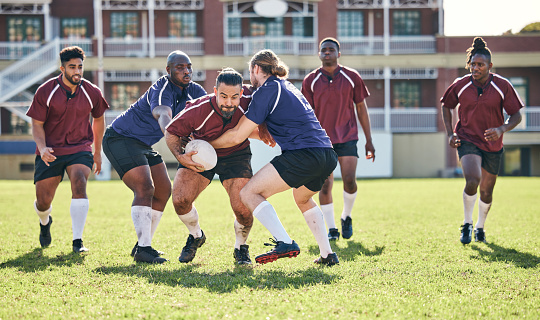 Rugby, fitness and tackle with a team on a field together for a game or match in preparation of a competition. Sports, training and teamwork with a group of men outdoor on grass for club practice