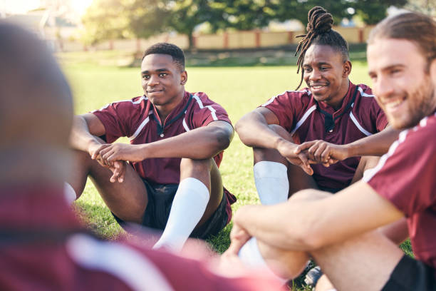 istock Sports, rugby and men on grass for rest at training, practice and exercise workout for match. Fitness, teamwork and male people relax for planning strategy for competition, challenge or game on field 1633788734