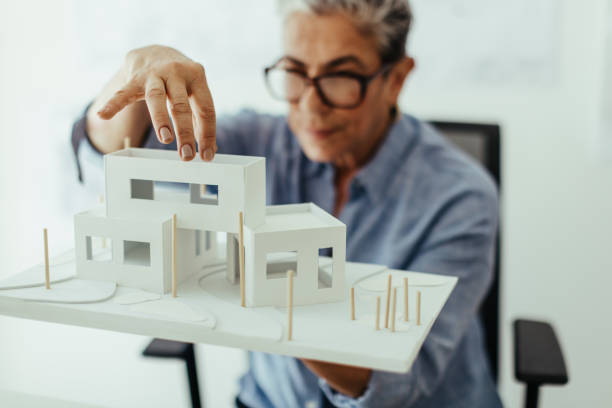 istock Professional design architect analyzing a 3D model of a house building in her office 1633790364
