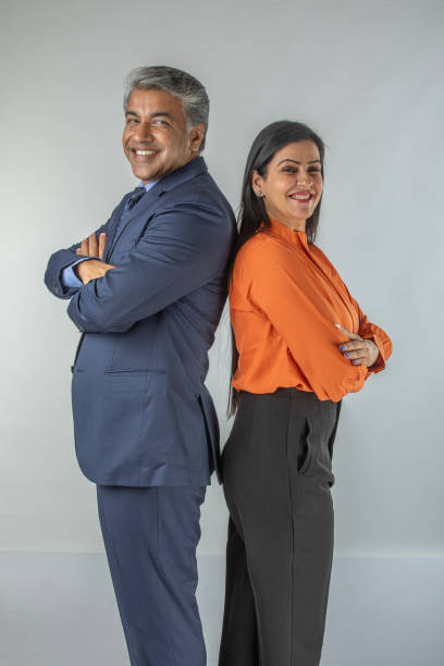 istock Smiling business partners standing back to back on white background 1633797635