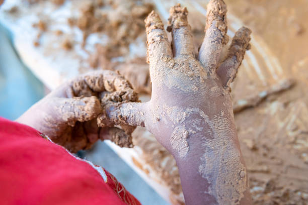Close up of a child cleaning his fingers out of mud