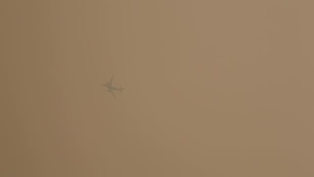 airplane flies through thick fog in new york city (smog and pollution from wildfires in nova scotia, canada) smoke and poor air quality, health advisory