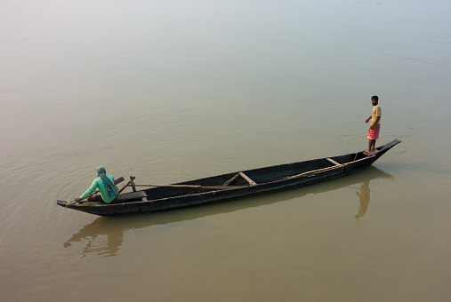 1st March 2023: Assam, India  Two fishermen on a small fishing boat on the Brahmaputra River in Assam, India