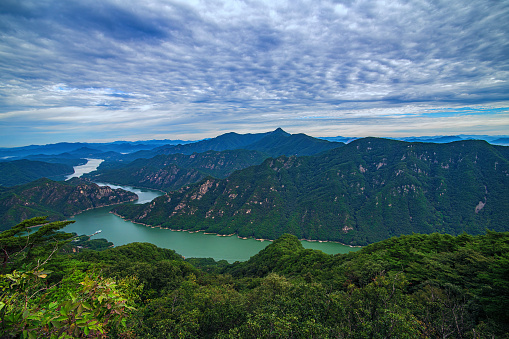Green mountains, beautiful flowing clouds, emerald green rivers at sunset.