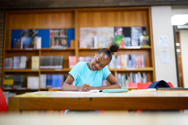 istock Girl doing her homework in the library 1633832347