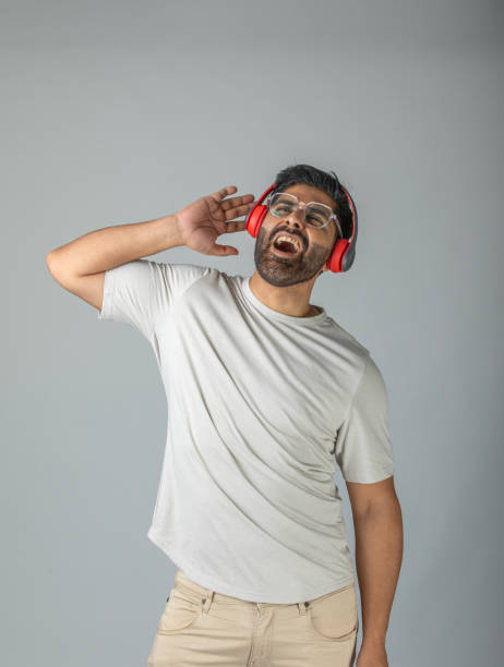 istock Cool man listening music against white background 1633833095
