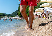 Close-up view of young man's legs on the beach