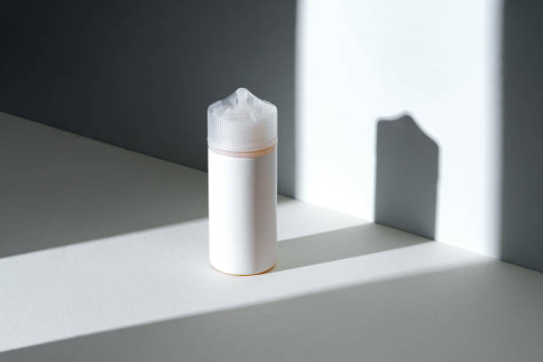istock Dropper bottle with vape liquid on white background in the sunlight with shadows 1633855854