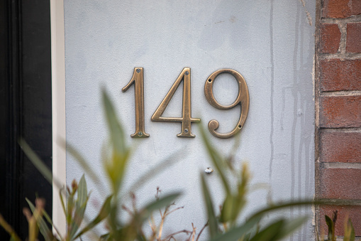 Metal house number sign on the wall outside a residential building in the city of Amsterdam