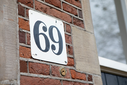 House number sign on the brick wall outside a residential building in the city of Amsterdam