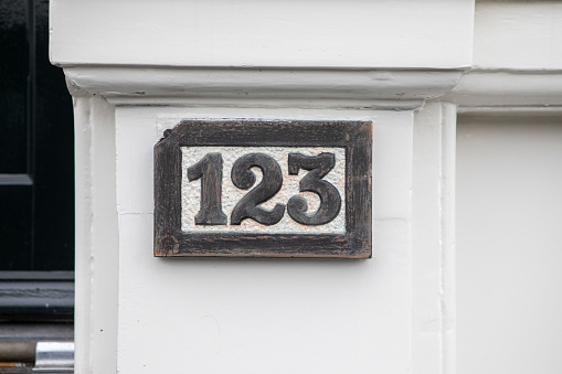 House number sign on the wall outside a residential building in the city of Amsterdam