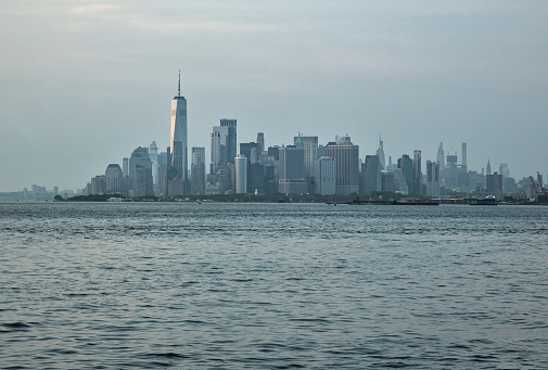 barge passing in front of downtown manhattan skyline in new york city (hudson river cityscape) harbor