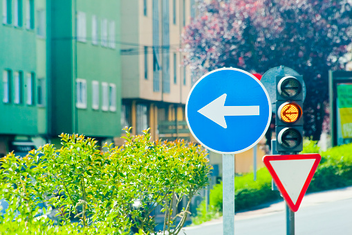 Amber traffic light, traffic arrow signs, street view. Lugo city, Galicia, Spain.