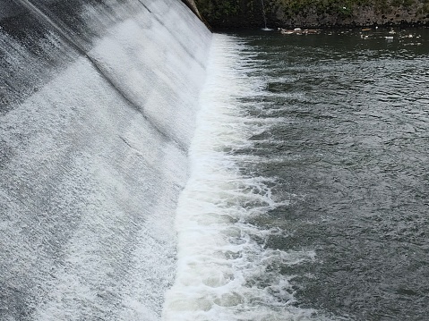 Water in long exposure rushing out of open gates of a hydro electric power station