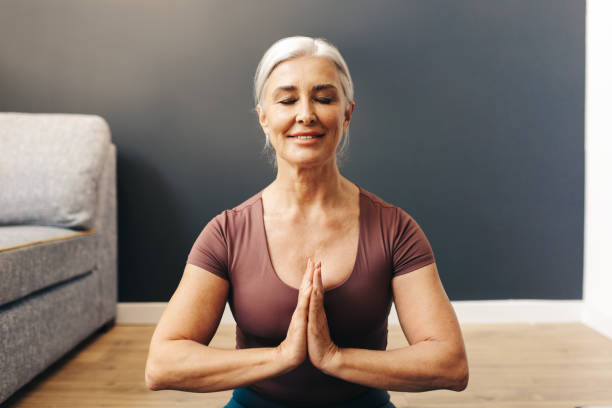 istock Peaceful woman meditating in prayer pose, connecting with her inner self 1633881761