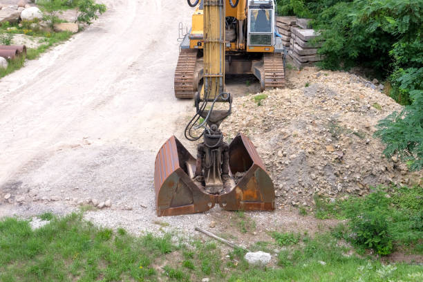 istock Excavator with a large bucket on a construction site next to a dirt road 1633886501