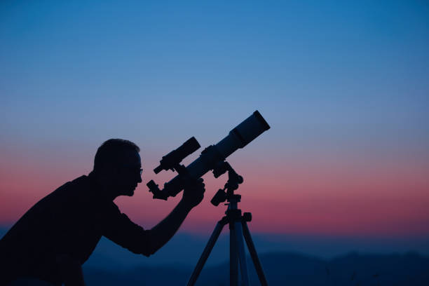 istock Astronomer looking at the night sky with a telescope. 1633930216
