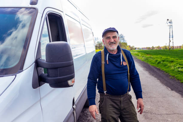 istock Happy confident male driver standing in front on his van and looking at camera. 1633947807
