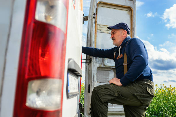 istock Mature van driver gets into his delivery van to check on the delivery. 1633951995