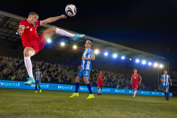 istock Young man kicking football mid-air 1633956964