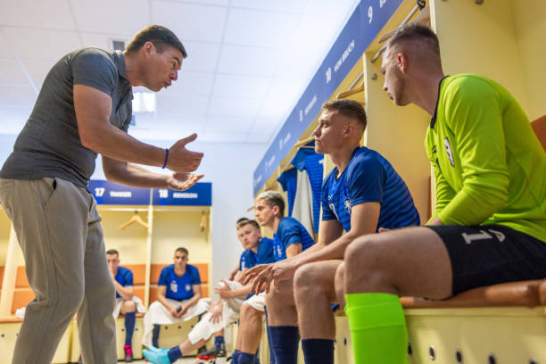istock Coach instructing male football players 1633956975
