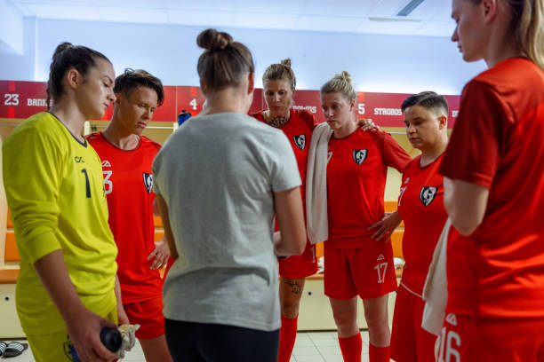 istock Coach instructing female football players 1633956984