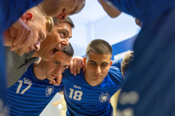 istock Football players huddling before match 1633956996