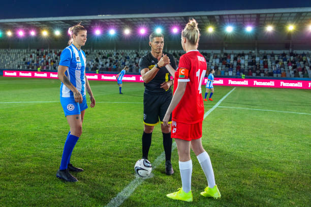istock Referee with team captions on football pitch 1633957004