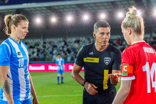 istock Referee with team captions on football pitch 1633957021