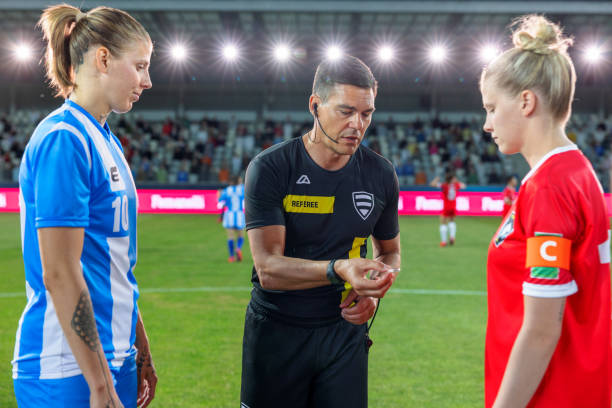 istock Referee with team captions on football pitch 1633957045