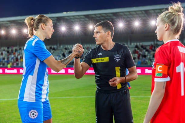 istock Referee with team captions on football pitch 1633957057