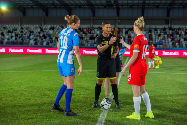 istock Referee with team captions on football pitch 1633957065