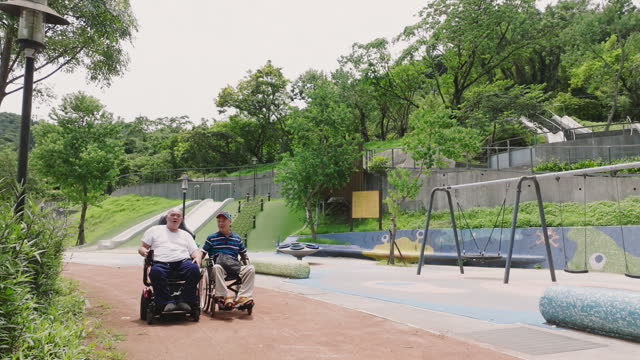 Two friends in wheelchairs taking a stroll in the park