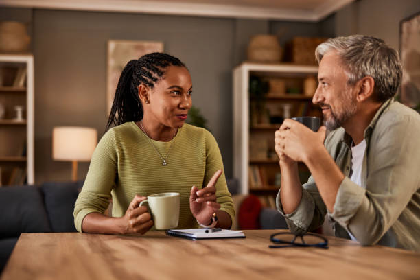 istock Mature couple talking while enjoying a hot drink at the table at home. 1633963264