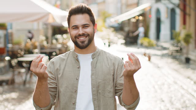 Cheerful rich adult man showing wasting throwing money, win lottery, share, celebrate in city street