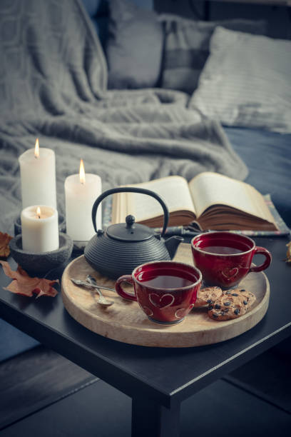 istock Two cups of tea on a serving tray on coffee table. 1634000569