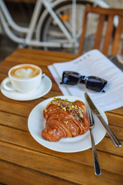 istock Breakfast time with croissant, coffee, and magazine 1634006006