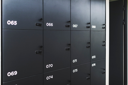 Hand of a mature man opening a safety deposit box. He is turning the key in the lock.