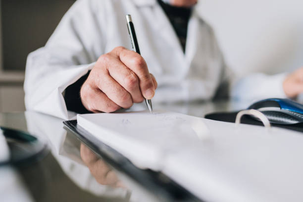 istock Close-up of doctor hand writing on doctor's office 1634060362