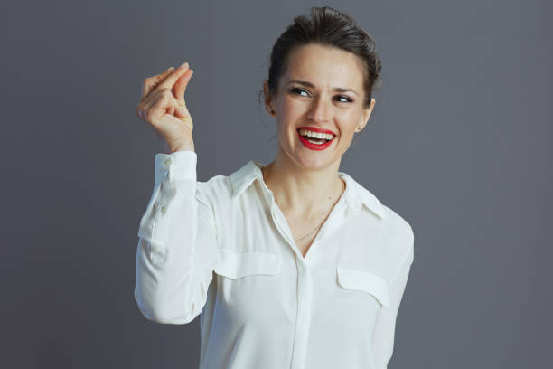 smiling trendy business woman fingers snapping isolated on grey smiling trendy 40 years old business woman in white blouse fingers snapping isolated on grey background. click finger stock pictures, royalty-free photos & images