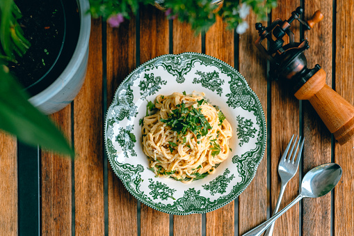 Traditional pasta dish with bacon, carbonara sauce, and fresh herbs.