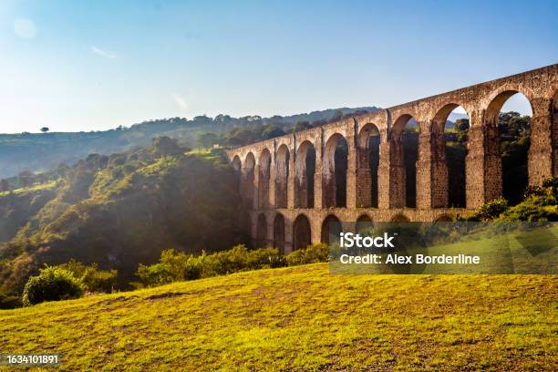 Aqueduct Between Mountains At Sunrise With Cloudy Sky In Arcos Del Sitio In Tepotzotlan State Of Mexico Stock Photo - Download Image Now