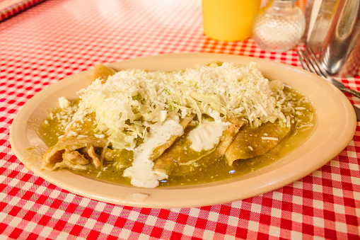 Enchiladas verdes con queso, comida típica mexicana, tortilla con salsa verde, pollo y queso