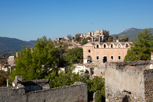 Historical Lycian village of Kayakoy, Fethiye, Mugla, Turkey. Drone aerial shot from above of the Ghost Town Kayakoy. Greek Village. Evening moody warm sun of the ancient city of stone