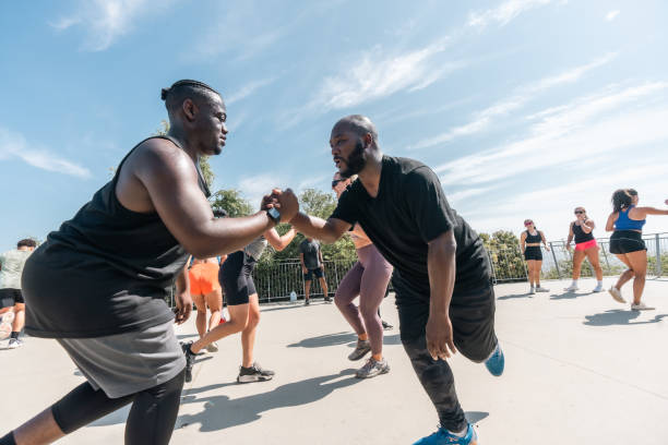 Two asian athlete men are joining hands and locking eyes with each other on the racetrack. Jogging or Running together, Outdoor exercise or training.