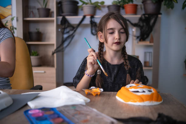 istock Painting a funny pumpkin mask for Halloween 1634164618